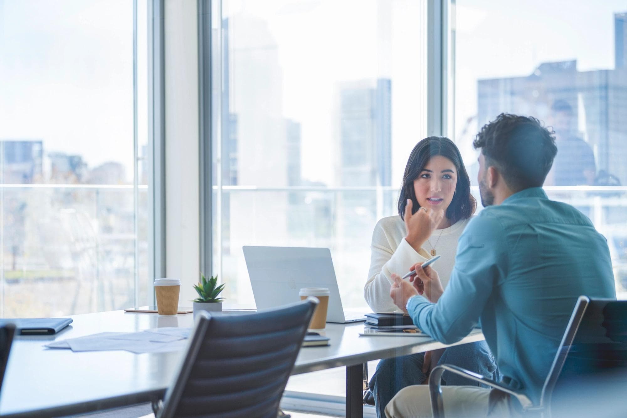 man and woman sitting at desk having business meeting