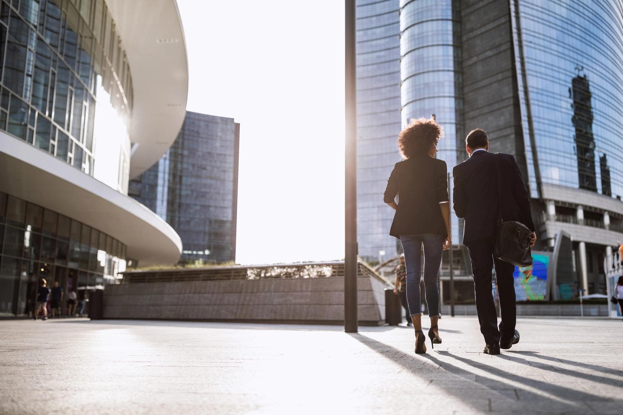 couple walking in front of office buildings