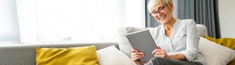 woman reading ipad while lying on couch