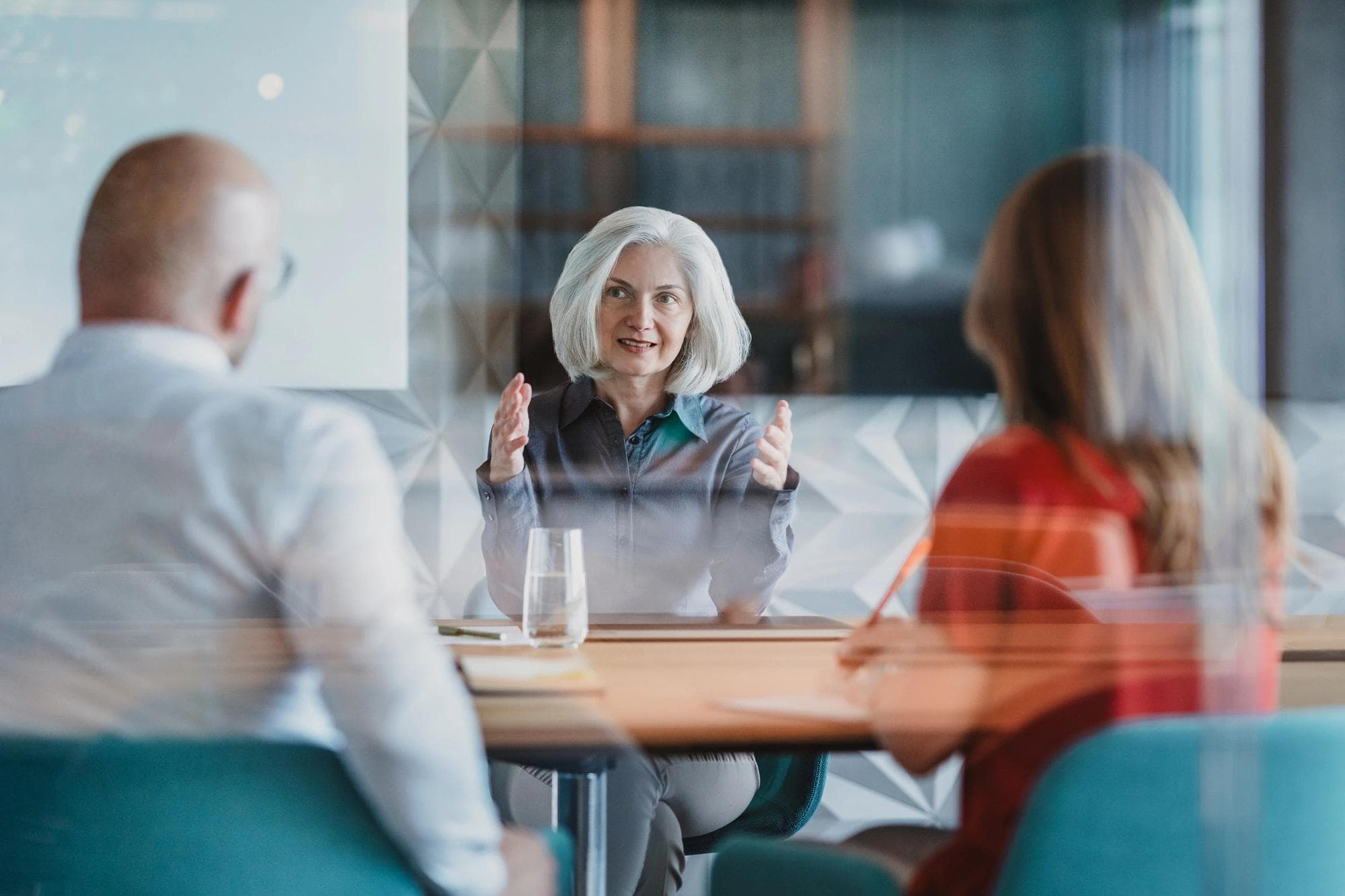 Mature businesswoman talking to colleagues with serious expression
