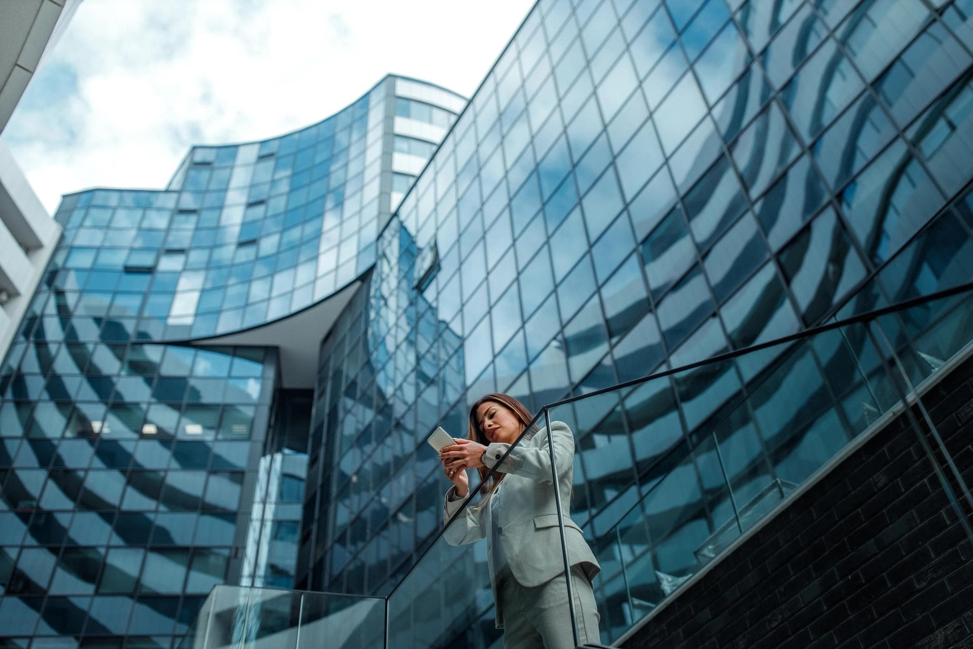 woman on phone standing in front of office building