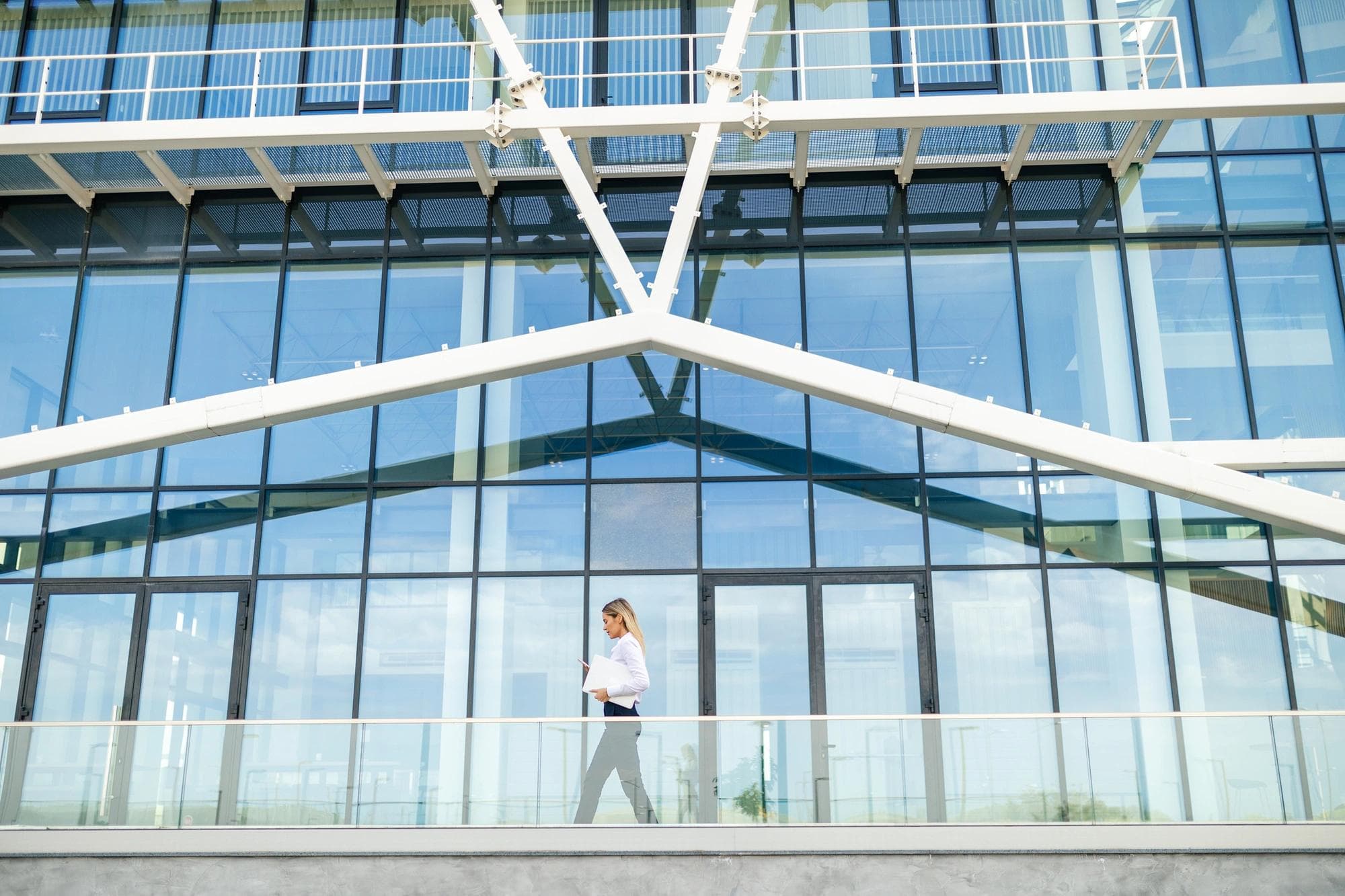 woman walking in front of modern office building