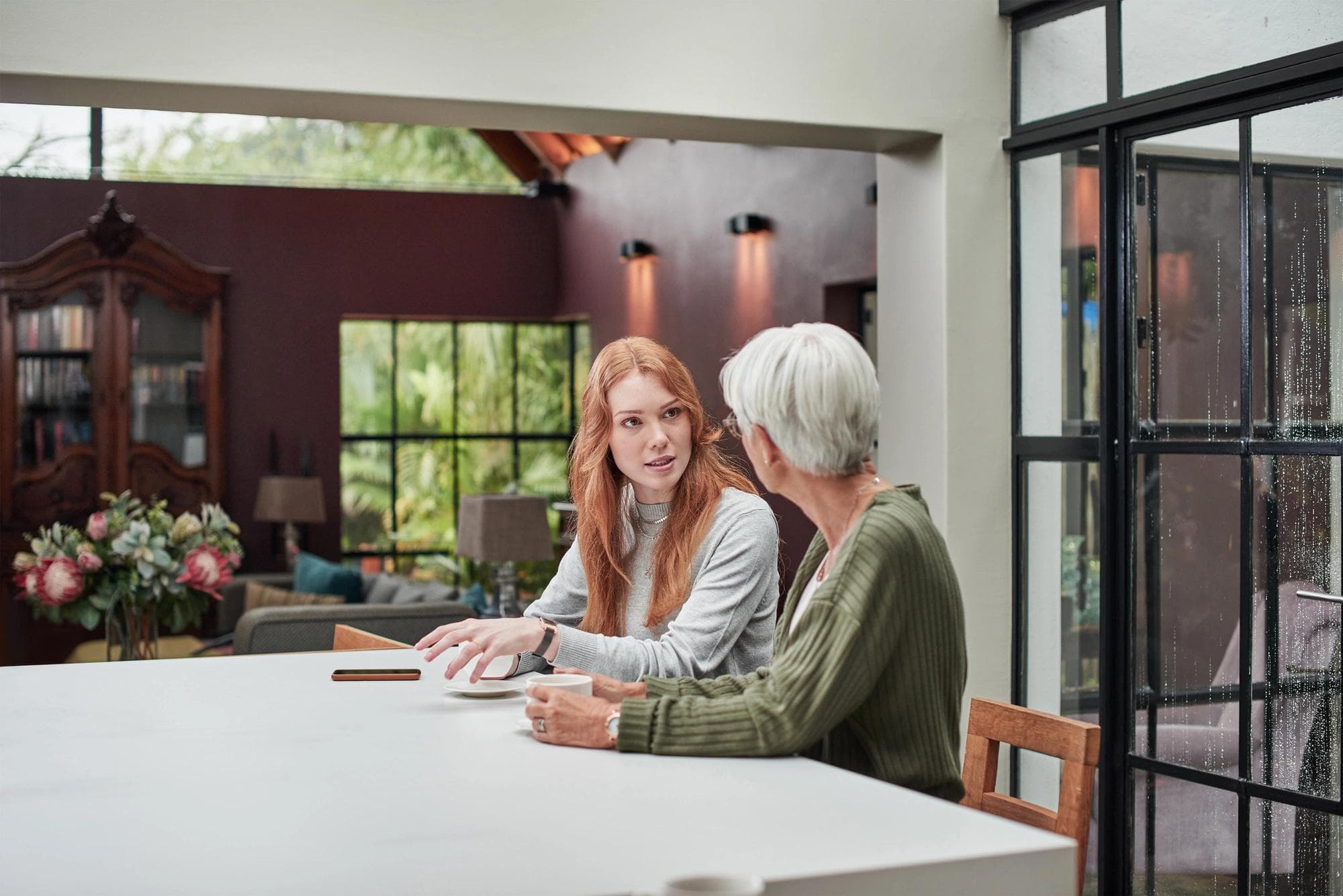 woman sitting at table with senior parent