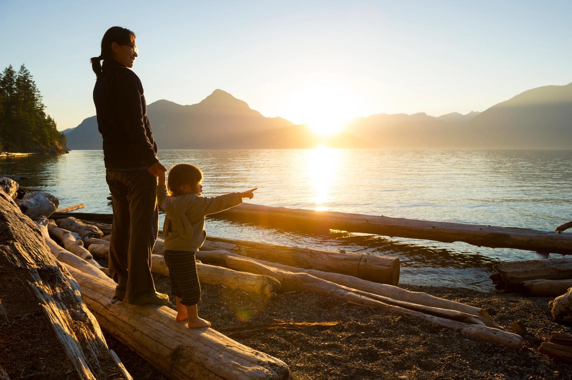 Mom holding child's hand on the beach