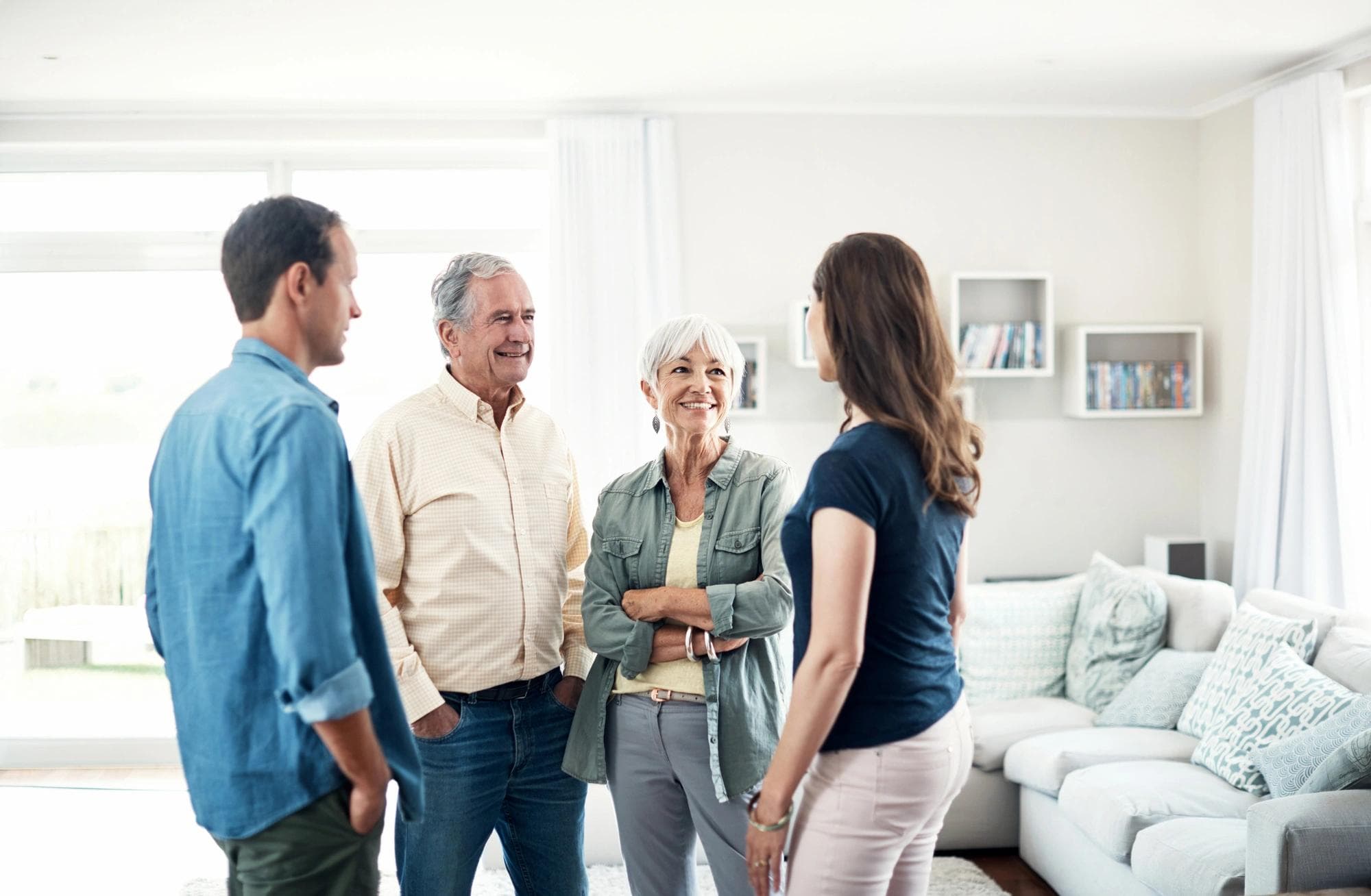 intergenerational family standing in home talking