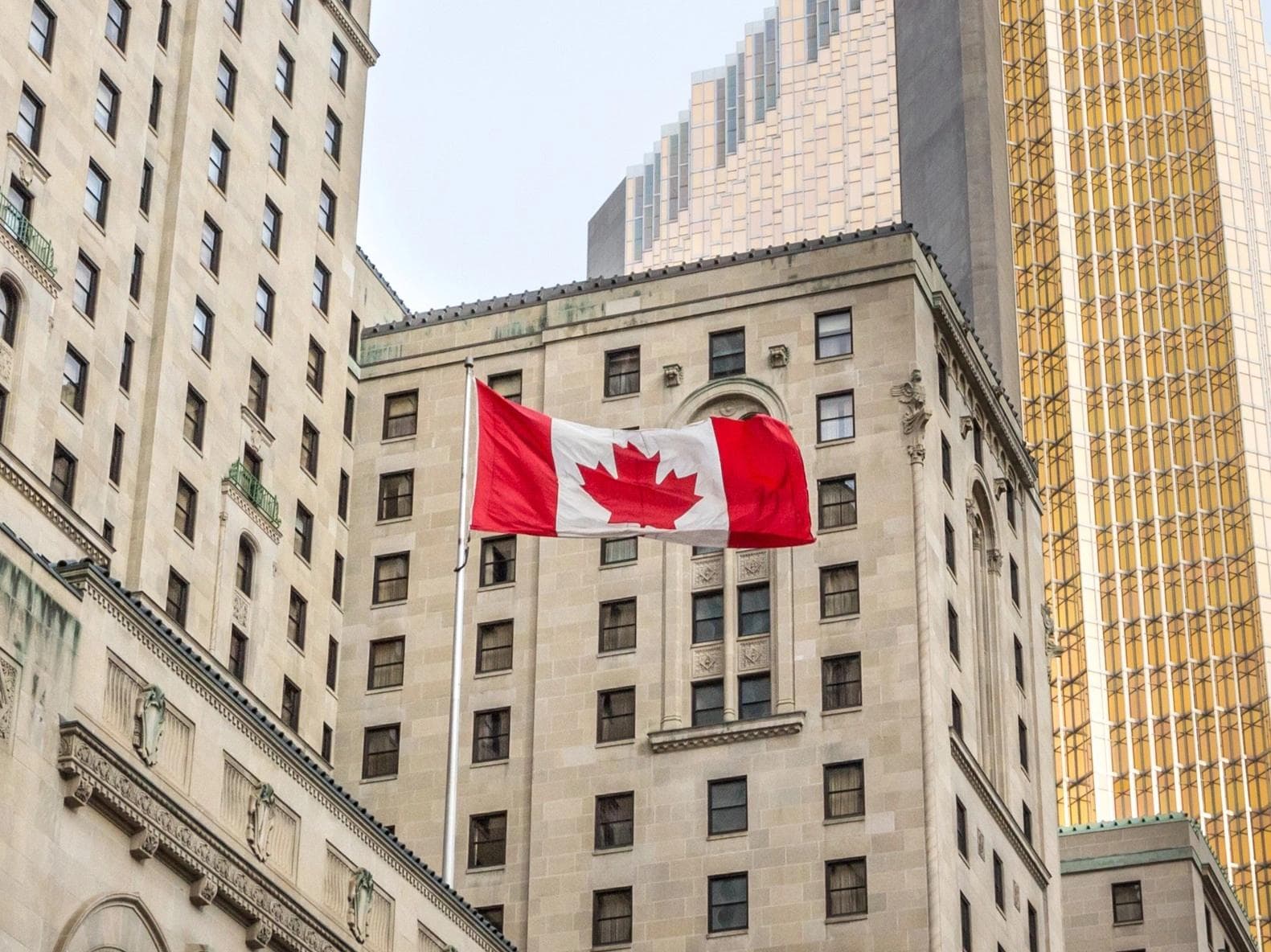 Canadian flag flying in front of business building in Toronto, Ontario